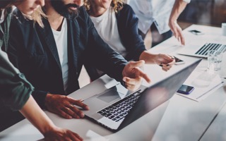 A group of experts are looking at a laptop