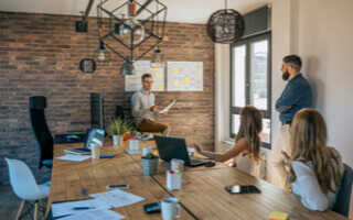 A Staff giving presentation to his team with sticky notes